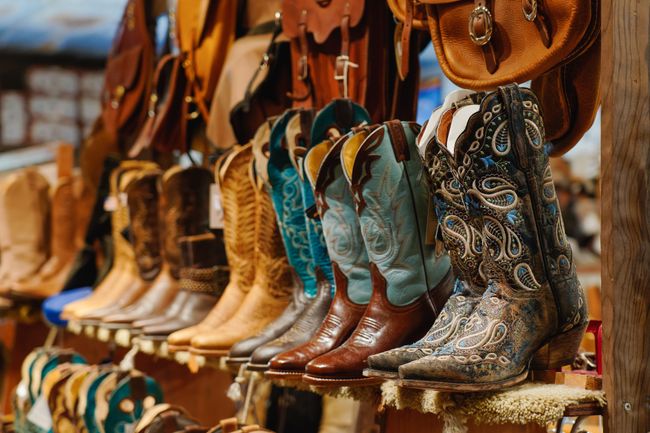 Stylish western boots with colourful embroidery on a shelf