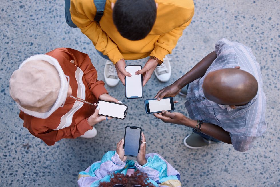 Friends, circle and phone in top view, outdoor and texting on social media.