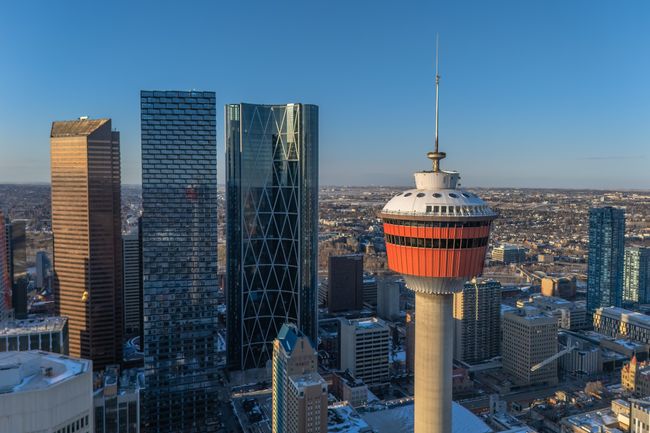 High angle view of the Calgary Tower and downtown skyline with modern skyscrapers at sunset.