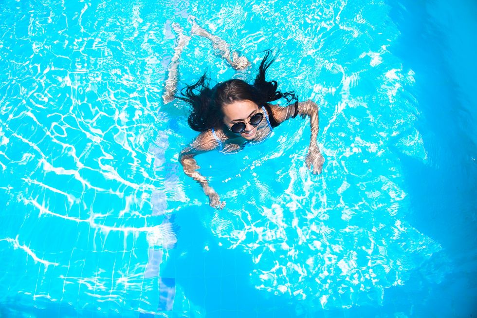 A beautiful girl in sunglasses is swimming in the pool girl in sunglasses is swimming in the pool