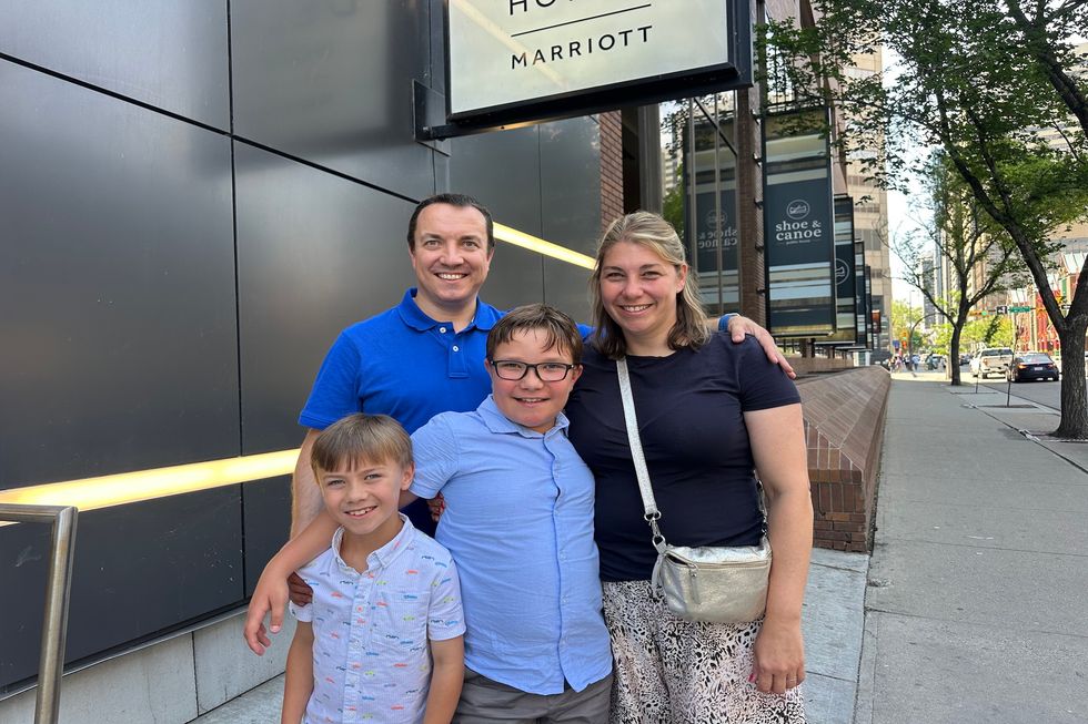 O'Grady Family standing in front of Delta Marriott Bonvoy Downtown in Calgary, Alta.