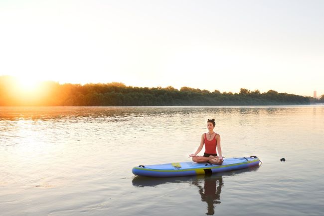 Meditating on a paddleboard during a beautiful morning sunrise