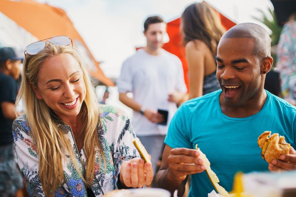 couple on date eating pickles and drinking beer having fun