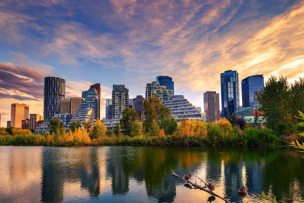 Sunset above city skyline of Calgary with Bow River, Alberta, Canada, photographed from Prince's Island Park.