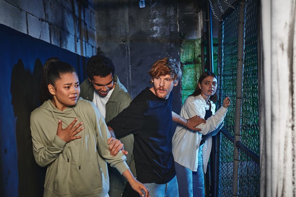 Field of Screams scared friends walking through secret passage in quest room, adventure and mystery