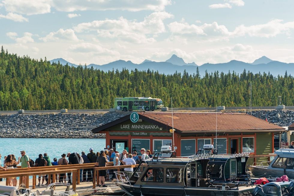 Lake Minnewanka cruise boat dock and ticket office buildings under Mount Aylmer in summer.