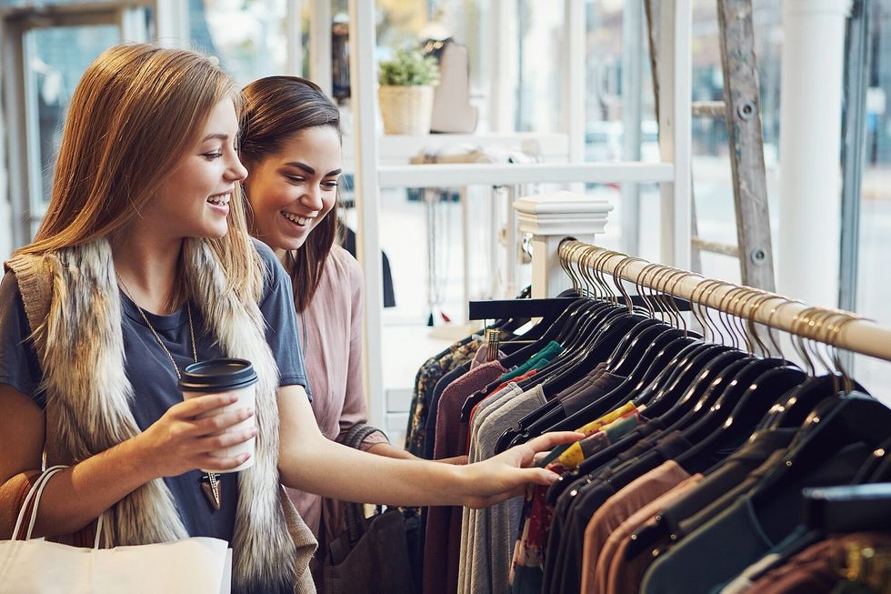 Fashion, shopping and friends with choice for clothes, sales and discount at luxury mall. Smile, retail store and customer with decision at boutique with funny women laughing or girls drinking coffee