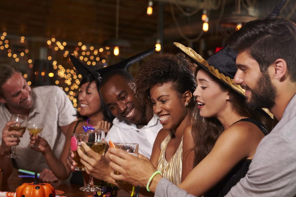 Friends enjoying a Halloween party at a bar making a toast Friends enjoying a Halloween party at a bar making a toast