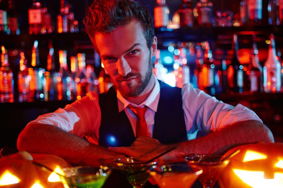 Bartender of Halloween night looking at pumpkin