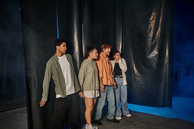 group of four scared friends standing inside of escape room during quest