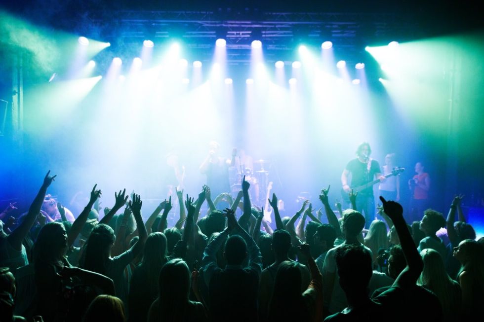 Music, dance and party with crowd at concert for rock, live band performance and festival show. New year, celebration and disco with audience of fans listening to techno, rave and nightclub event