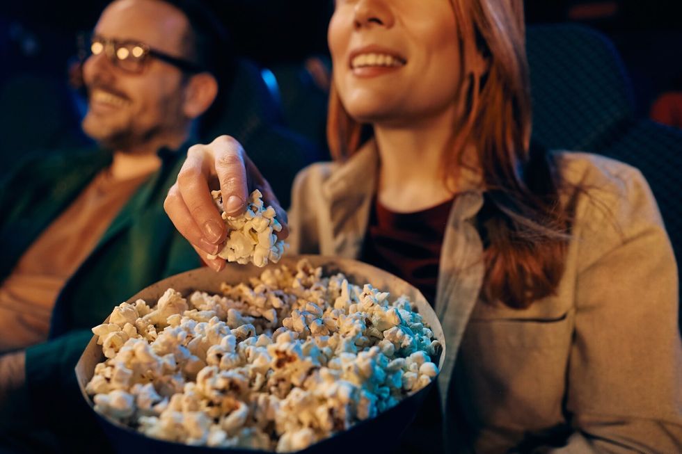 Close up of woman enjoying in a movie and popcorn at cinema. Close up of woman enjoying in a movie and popcorn at cinema.